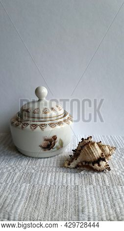 A Saucepan From A Table Set In Combination With A Seashell