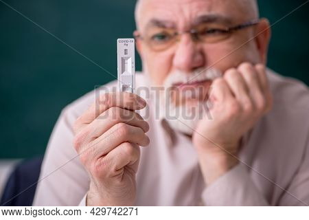 Old male teacher in pandemic concept