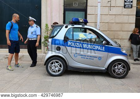 Matera, Italy - June 3, 2017: People Walk By A City Police (polizia Municipale) Vehicle In Matera, I