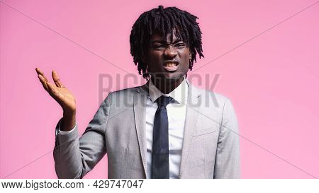 Skeptical African American Businessman Pointing With Hand Isolated On Pink