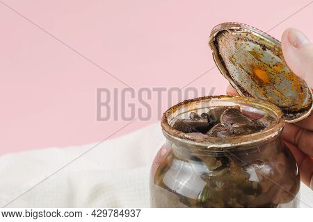 Botulism, Food Poisoning From Canned Foods Concept. Handholds Rusty Tin Lid With Black Stains. Opene