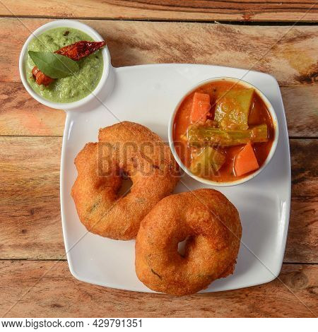 Indian Fried Snack Medu Vada With Sambar And Coconut Chutney In Plate On Rustic Wooden Background, S
