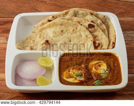 Indian Combo Meal Egg Masala With Naan, Served Over A Rustic Wooden Background, Selective Focus