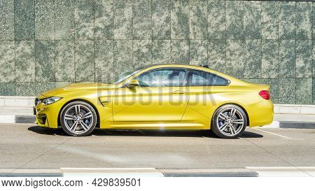 Yellow Bmw M4 Coupe F82 Parked On The Background Of Granite Wall, Side View. Moscow, Russia - July 2