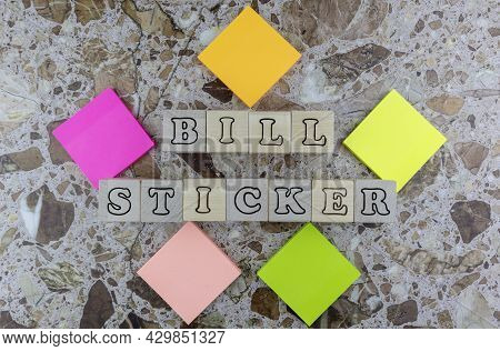 Biller Sticker Concept With Brightly Colored Memo Pads Forming A Frame Around Wooden Cubes With Alph