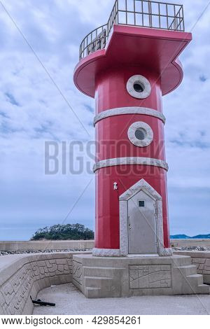 Red Lighthouse On Concrete Pier Located In Mongsan Harbor In Taean, South Korea.