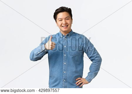 Smiling Pleased Asian Male Student With Braces, Showing Thumbs-up, Recommend Product Or Service With
