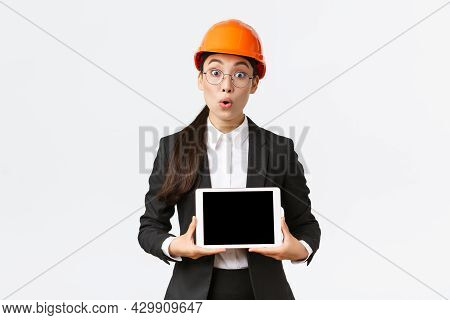 Impressed Asian Female Construction Engineer, Businesswoman In Safety Helmet And Suit Showing Chart,