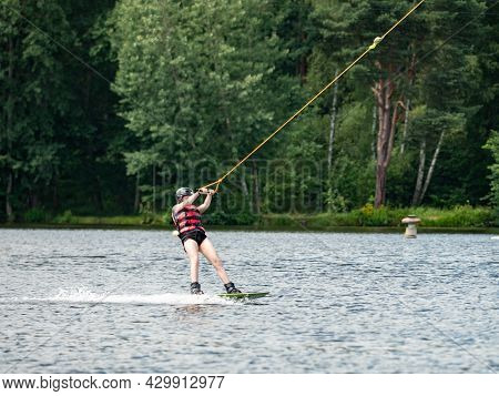 Straz, Czechia. 29th Of July, 2021. Wake Boarding  Boy On Lake, The Forest In Blurry Background.