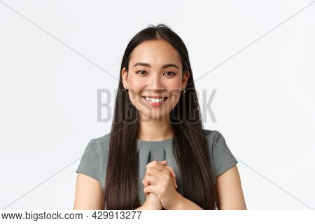 Close-up Of Happy Attractive Asian Woman Receiving Award Or Praises At Work, Holding Hands Clasped T