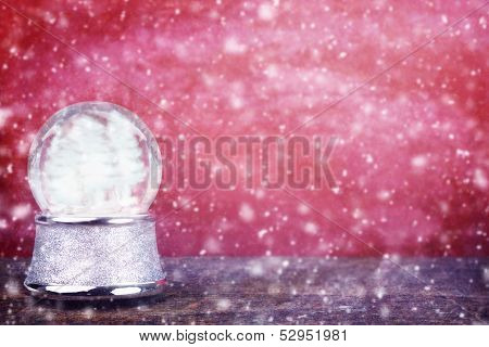 Empty Snowglobe Against Red