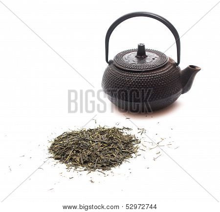 Photo of green bulk tea and a black japanese teapot