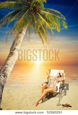 Beautiful young woman in bikini on the beach onder a coconut tree 