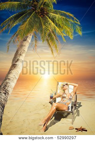 Beautiful young woman in bikini on the beach onder a coconut tree 