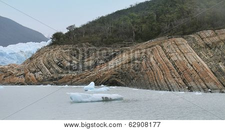 Icebergs Floating On A Lake With A Forest Background.