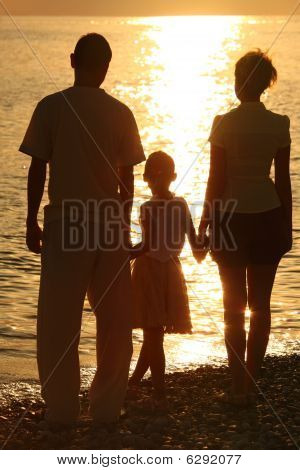 drei Silhouetten gegen glossing Meer. Eltern und Tochter.