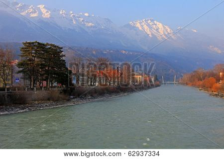 INNSBRUCK, AUSTRIA - MARCH, 2013 - Buildings and Mountains along the Inn River in Innsbruck, Austria during the sunset on March 27, 2013. Inn River is a right tributary of the Danube