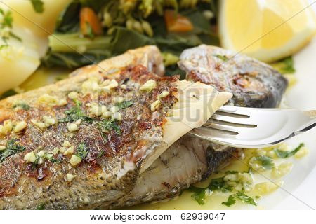 very fresh seabream fish grilled with turnip greens - traditional food from Portugal