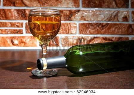 Wine bottle and glass on brick wall background