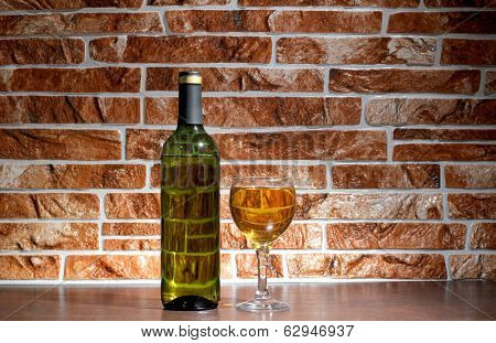 Wine bottle and glass on brick wall background