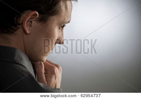 Portrait Of Contemplated Young Man With Hand On Chin