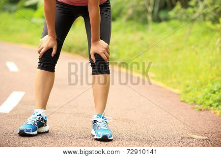 tired woman runner taking a rest after running hard in countryside road. sweaty athlete after marath