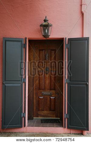 Brown shutters on red stucco wall