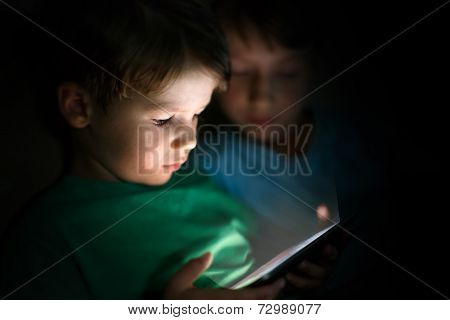 Little Boys Playing On Tablet At Night