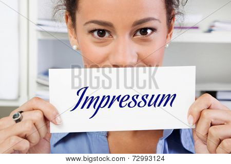 Hands of woman holding sign: Impressum in german letters.