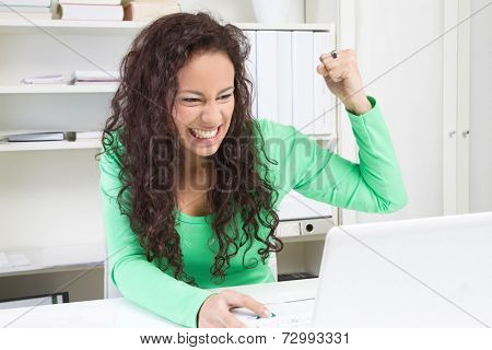 Angry young woman working on computer