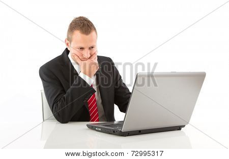 Caucasian businessman working on laptop and pondering