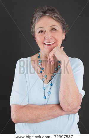 Portrait of an elderly smiling attractive woman on black background.