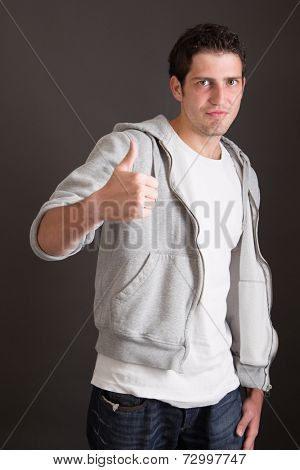 Three-quarter length of young Caucasian man with thumb up