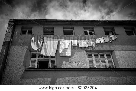 Monochrome Photo Of Clothes Drying Outside Of Grungy Building