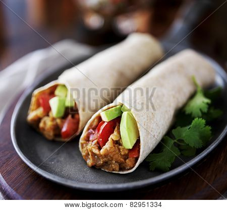 two vegan burritos with avocado, tomato and lentils