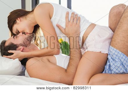 Young couple having fun in bed at home in bedroom