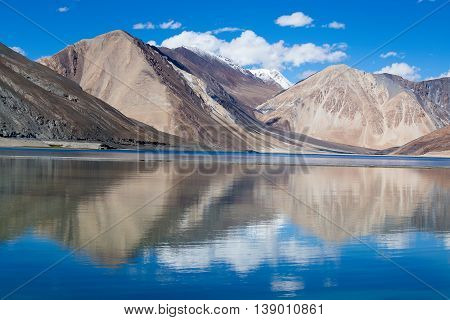 Sunny day at Pangong Lake and Himalayan mountain. Pangong Lake is an endorheic lake in the Himalayas situated at a height of about 4350 m in Ladakh India. It is 134 km long from India to Tibet