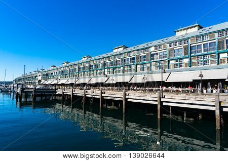 Finger wharf restaurants and hotel in Woolloomooloo bay with unrecognisable people in the distance. Sydney Australia