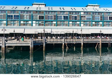 Finger wharf restaurant in Woolloomooloo bay with unrecognisable people in the distance. Sydney Australia