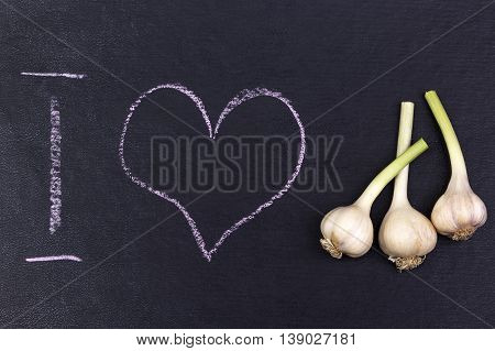 Ground with i love text and garlicon the black background.