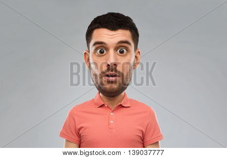 emotion, facial expressions and people concept - surprised man in polo shirt over gray background (funny cartoon style character with big head)