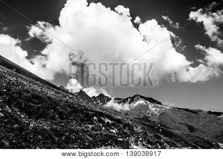 it is black a white landscape, white clouds, mountains
