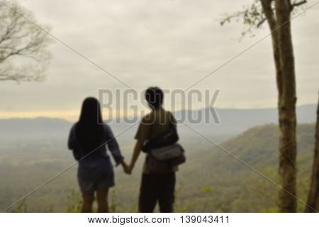blurred image of couple looking view at mountain