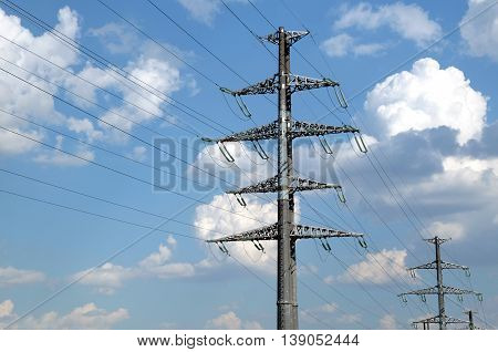 High-voltage power line gray metal props with many wires closeup view