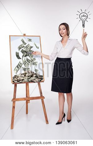 The young business woman presenting a lucrative and money idea on the board on white background.