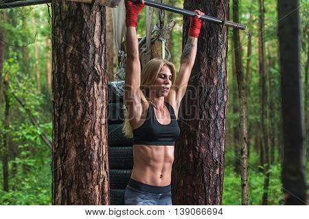 Fit woman preparing to do pull ups on horizontal bar