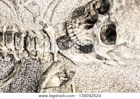 Human skeleton with coin in the mouth. Replica