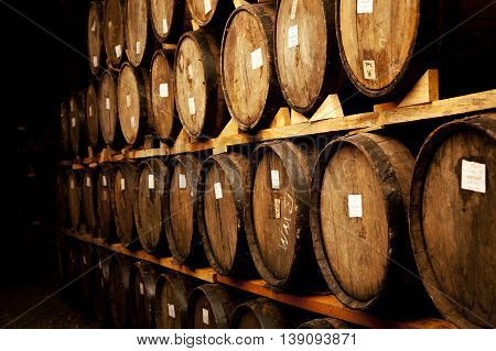 Wine barrels stacked in the old cellar of the winery.