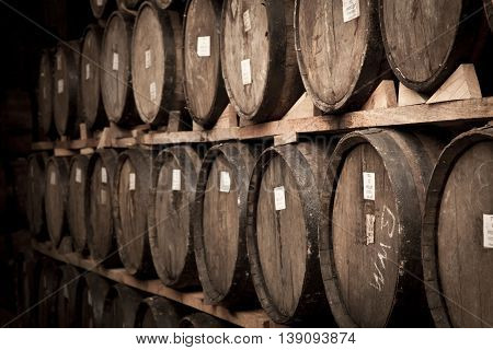 Wine barrels stacked in the old cellar of the winery.