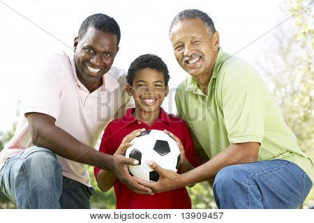 Bedstefar med søn og barnebarn i parken med fodbold